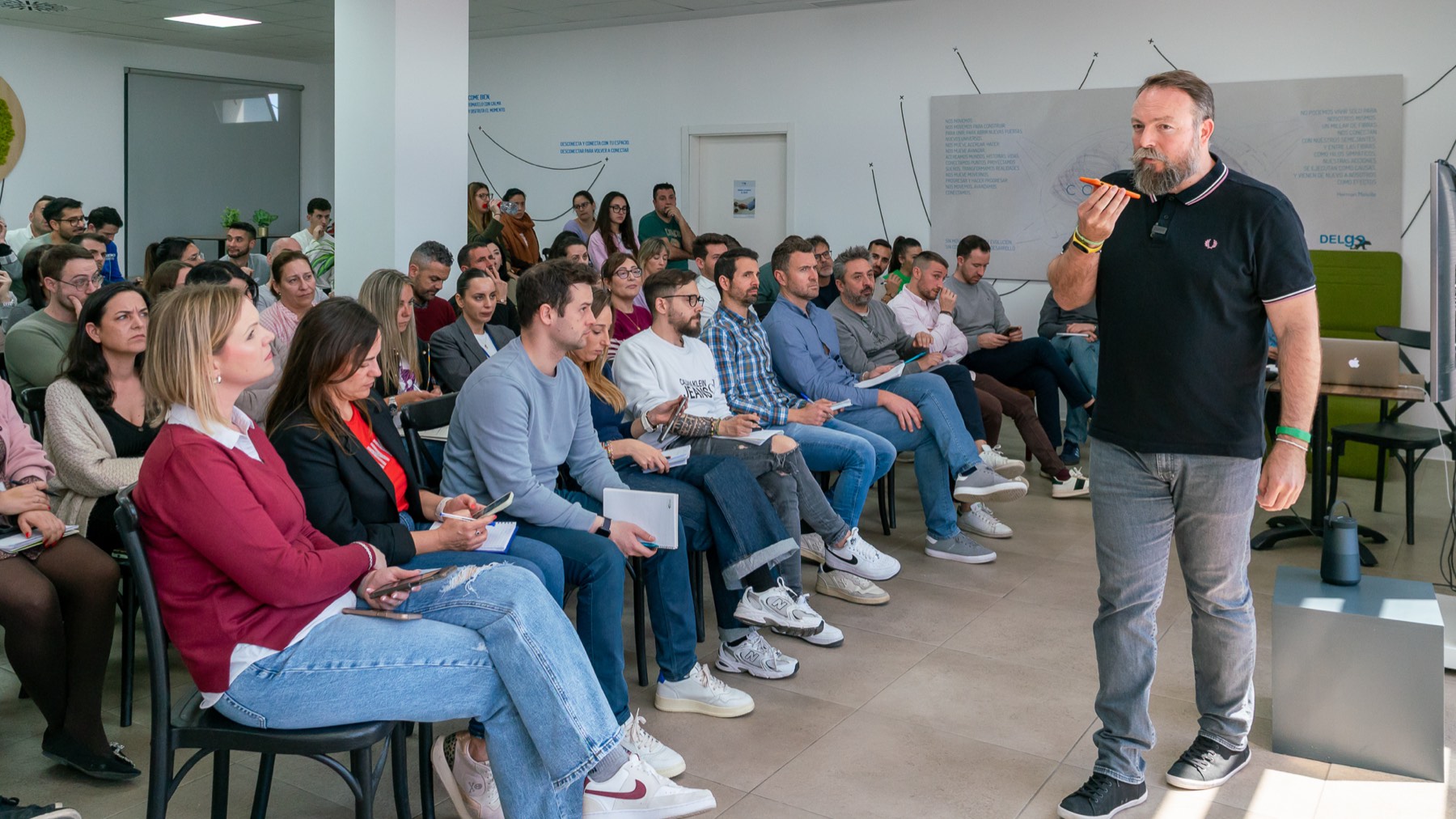 Una sala de empresarios sentados durante una sesión de IA Estratégica, con el ponente de pie dirigiéndose a ellos.